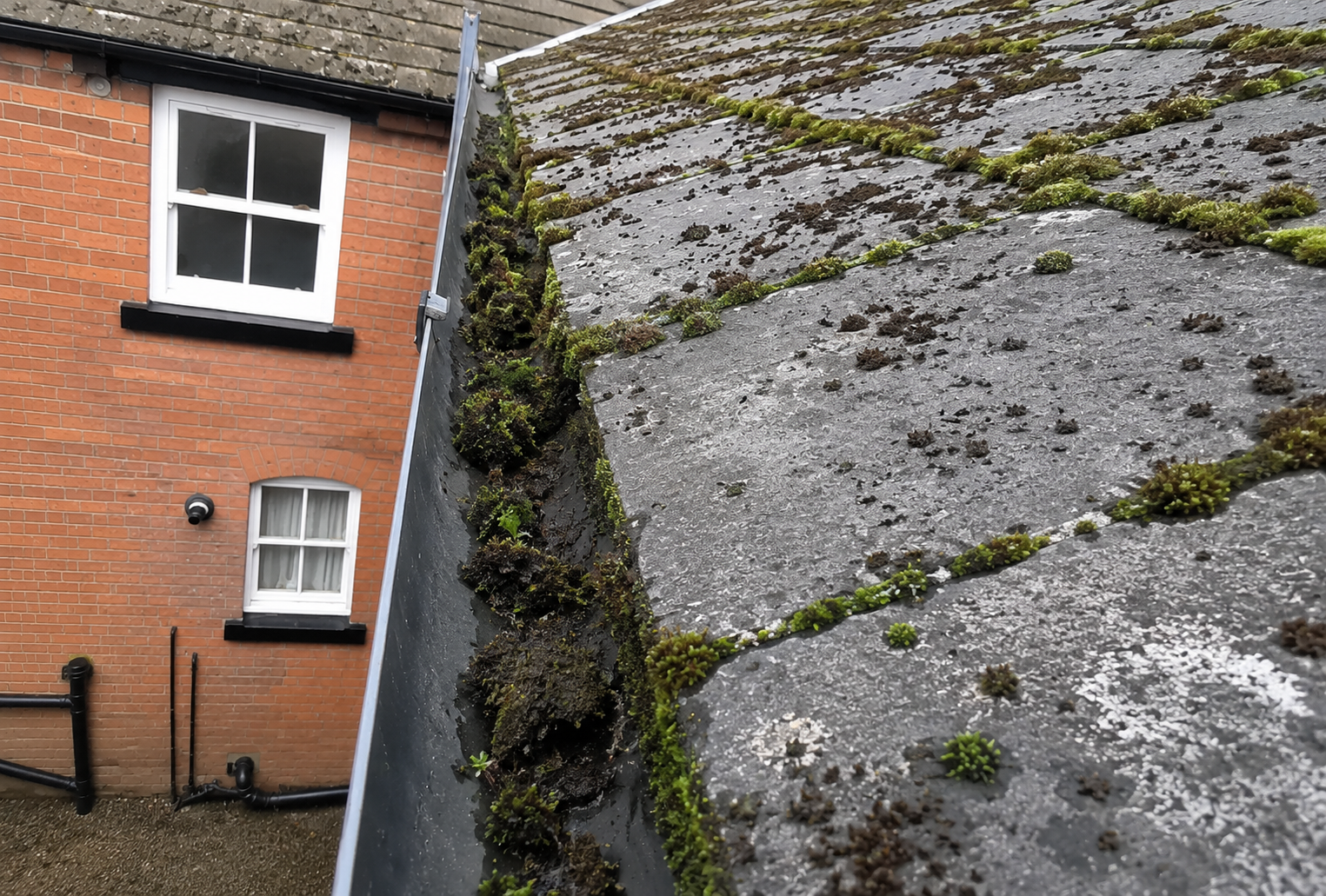 Birmingham gutter before summer inspection showing accumulated debris, silt and hidden faults